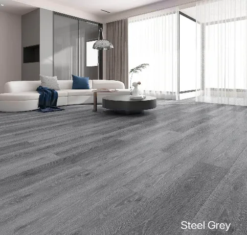 Modern living room with a white sectional sofa, blue cushions, and a round coffee table on steel grey wood flooring. Floor-to-ceiling windows and sheer curtains allow natural light to fill the room. "Steel Grey" text displayed in the bottom corner.